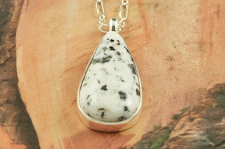 White Buffalo Turquoise set in Sterling Silver Pendant. This Beautiful Stone is formed from the minerals Calcite and Iron. It is mined near Tonopah Nevada. Free 18" Sterling Silver Chain with purchase of pendant. Created by Navajo Artist Tony Garcia. Signed by the artist.